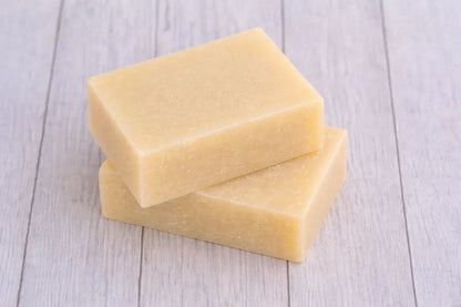 Two natural pet soap bars stacked on a wooden surface